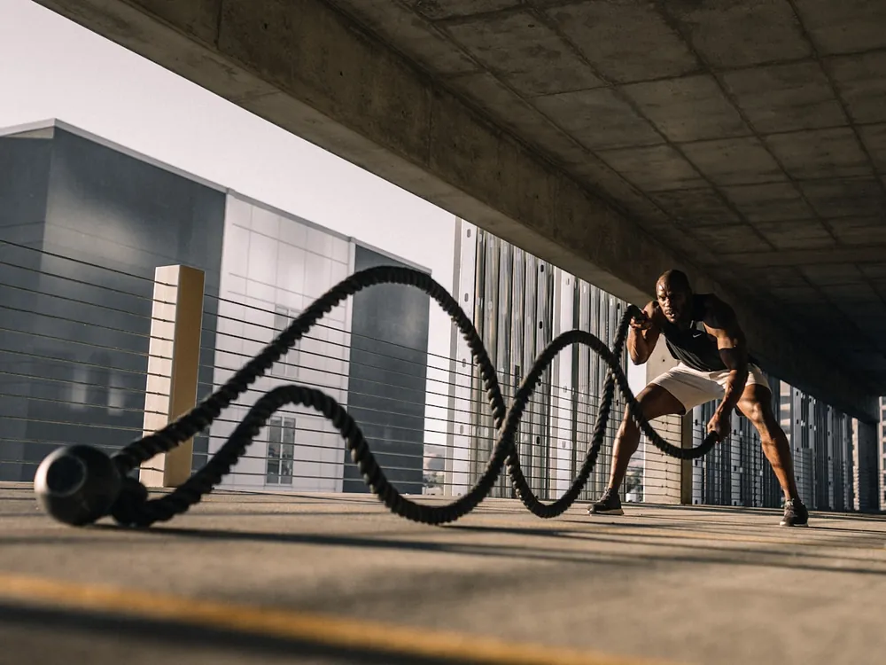 Athlete training with battle ropes in a concrete space