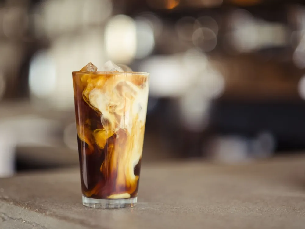 Iced latte in a tall glass on a café table